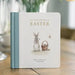 Book titled 'Our Little Adventure at Easter' with illustrations of bunnies and a basket on a wooden surface.