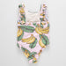 One-piece swimsuit with banana and leaf pattern on a light gray background