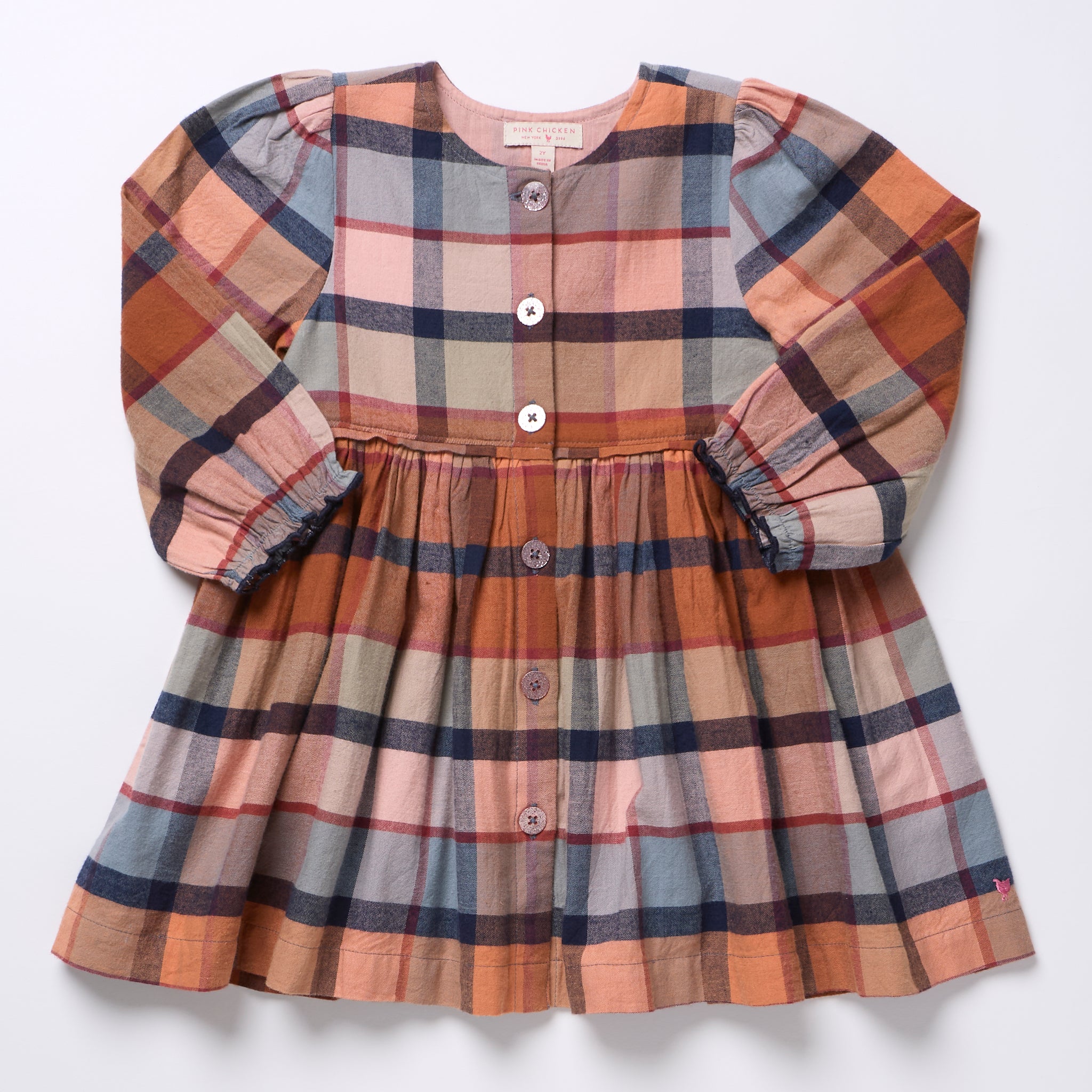 Pink Chicken girls plaid dress in warm rust blue and cream tones with long sleeves button front and gathered skirt for a classic children’s wardrobe style