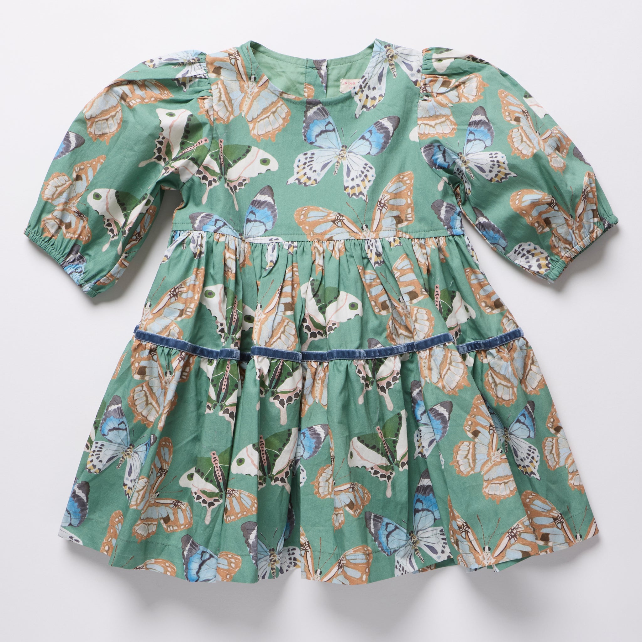 Green girls dress with puff sleeves and tiered skirt covered in colorful butterfly prints from Pink Chicken