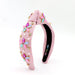Pink headband with decorative elements on a white background