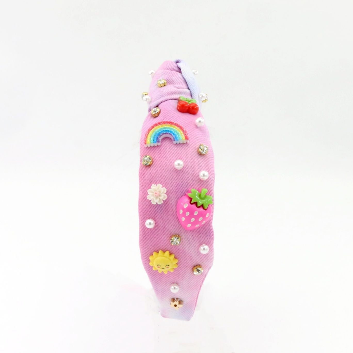 Pink hairband with decorative elements on a white background