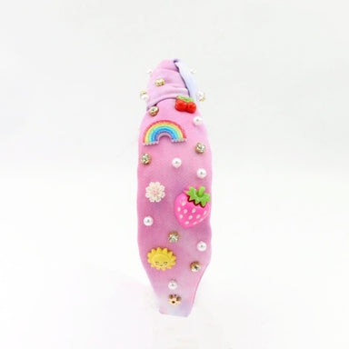 Pink hairband with decorative elements on a white background