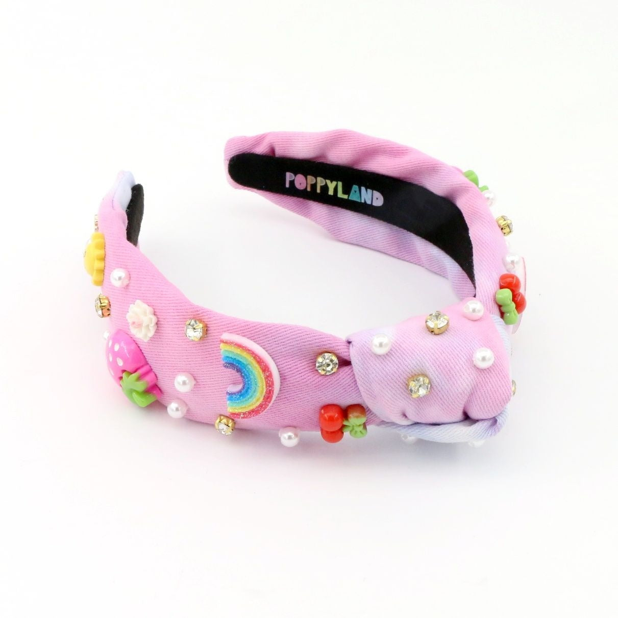 Pink sleep mask with rainbow design and decorative elements on a white background