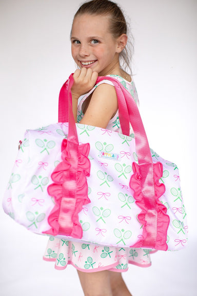 Young girl holding a large pink and white bag with ruffles on a white background