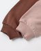 Close-up of two ribbed knit sleeve cuffs in warm brown and dusty pink, laid diagonally on a clean white background.