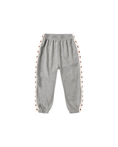 A pair of heather gray jogger sweatpants with white side stripes featuring a repeating red embroidered pattern, shown against a plain white background.
