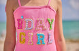Pink tank top with 'B'DAY GIRL' text in colorful sequins on a beach.