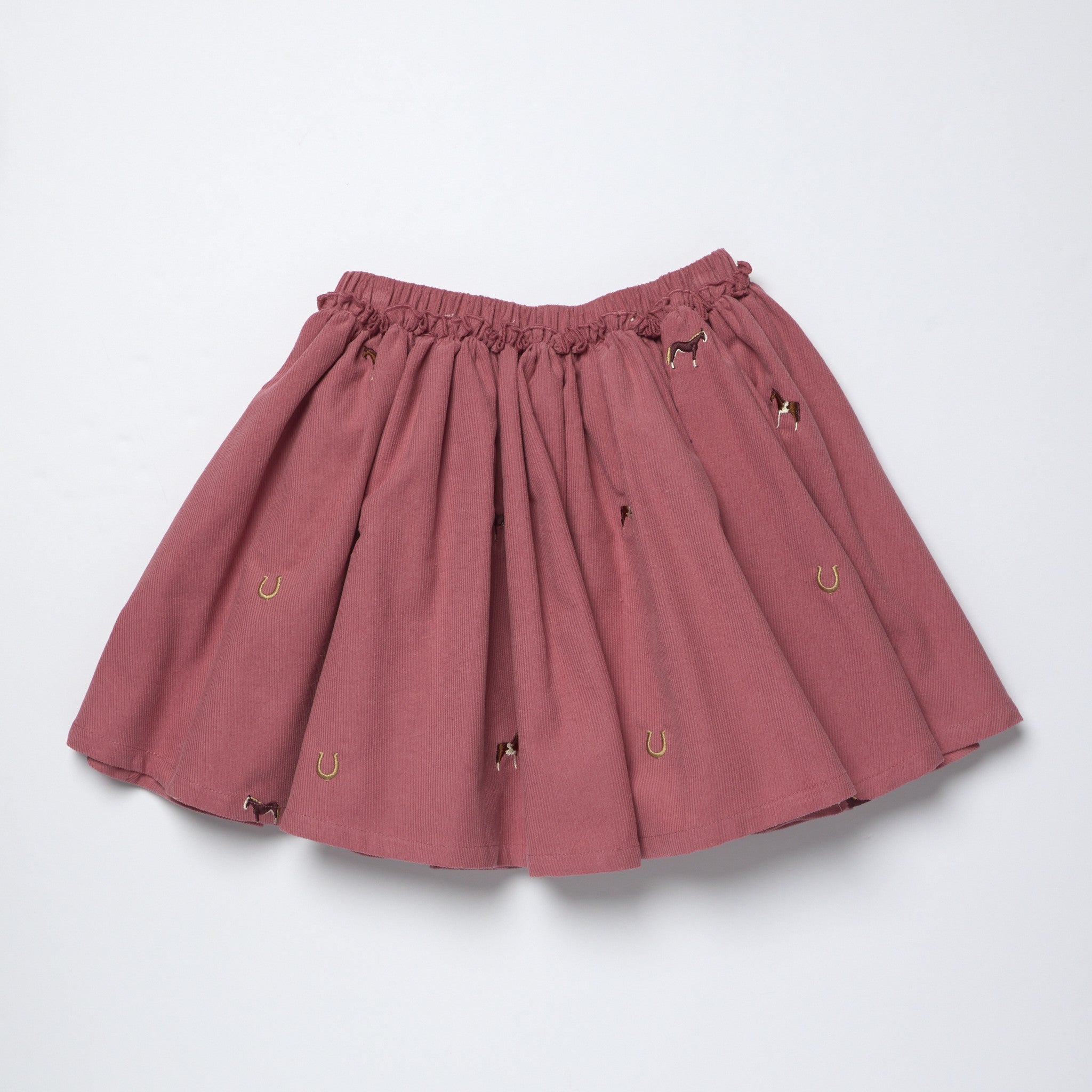 Mauve girls skirt by Pink Chicken with an elastic waist and playful horse and horseshoe embroidery throughout the gathered design