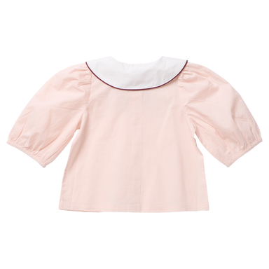 A light pink children's blouse shown from the back, featuring a white Peter Pan collar with a thin dark red piping trim and voluminous elbow-length puff sleeves.