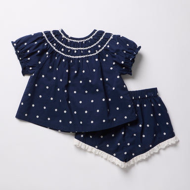 Navy blue top and shorts set with white polka dots on a light gray background