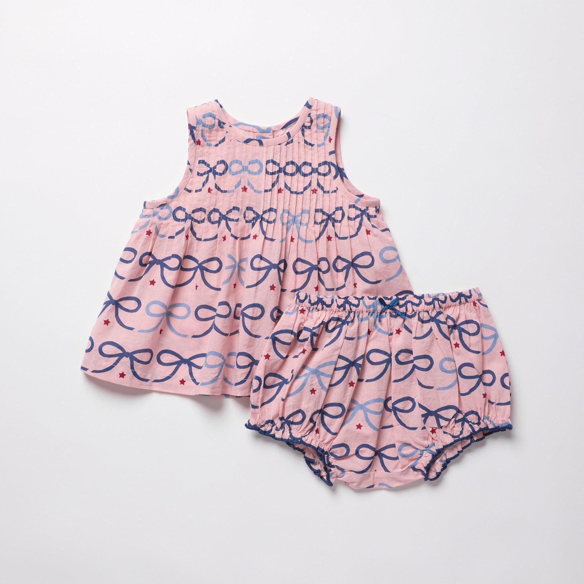 Pink baby dress with bow pattern on a white background