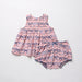 Pink baby dress with bow pattern on a white background