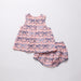 Baby dress and bloomers set with bow pattern on a light gray background