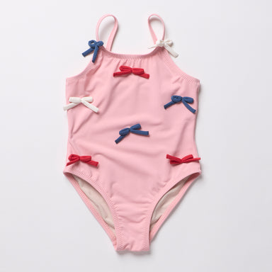 Pink children's swimsuit with bow details on a light gray background