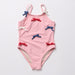 Pink children's swimsuit with bow details on a light gray background