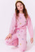 Young girl wearing a pink outfit with heart patterns on a white background