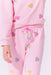 Pink sweatsuit with heart patterns on a light pink background