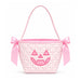 A pink gingham quilted mini bucket bag with a pink satin handle, bow details on the sides, and an embroidered jack-o'-lantern face on the front.