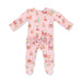 A pink footed baby sleeper with a ruffled back, decorated with a festive Christmas print featuring Santa Claus, reindeer, and snowflakes.