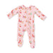 A pink footed baby sleeper with a front zipper, decorated with a festive Christmas print featuring Santa Claus, reindeer, and snowflakes.