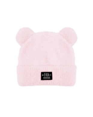 A light pink fuzzy beanie hat with two small bear ears on top and a small black rectangular logo patch on the front cuff, shown against a plain white background.