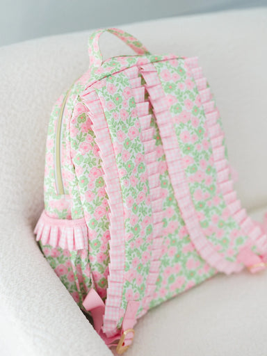Floral patterned backpack with ruffles on a light background