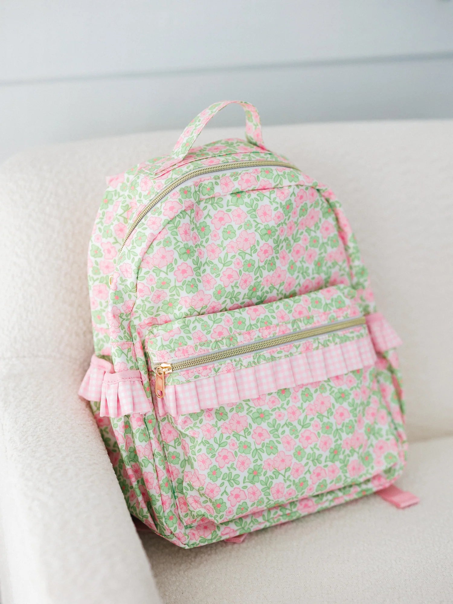 Floral patterned backpack with pink accents on a light background