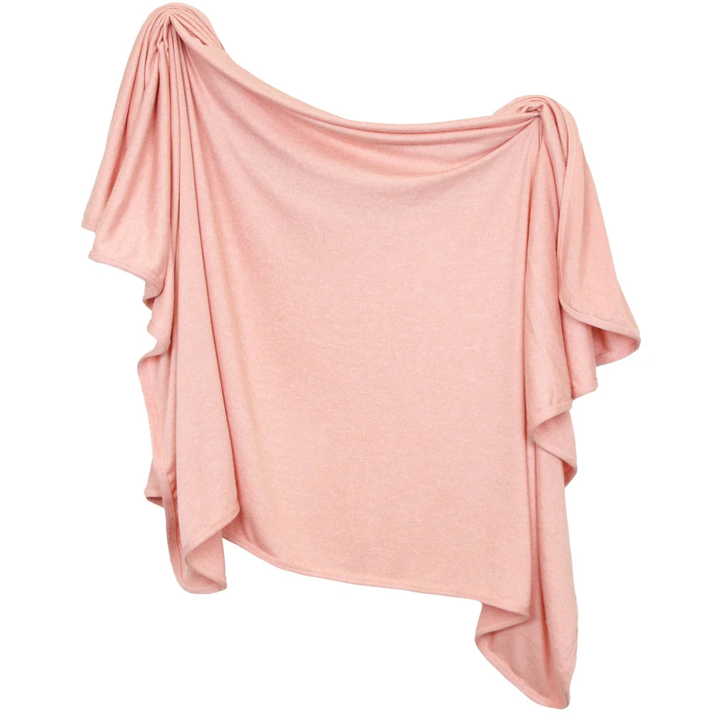 A pink blanket draped on a white background