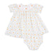 A baby dress set in white fabric, featuring a repeating pattern of orange pumpkins, green leaves, and a light pink trellis design. The dress has ruffled short sleeves and a smocked neckline with small embroidered bows.