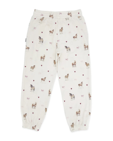 Off-white jogger pants with an all-over print of horses and small pink hearts, shown flat against a white background.