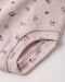 Close-up of a light lilac eyelet fabric diaper cover with a small floral print, showing textured material against a plain light background.
