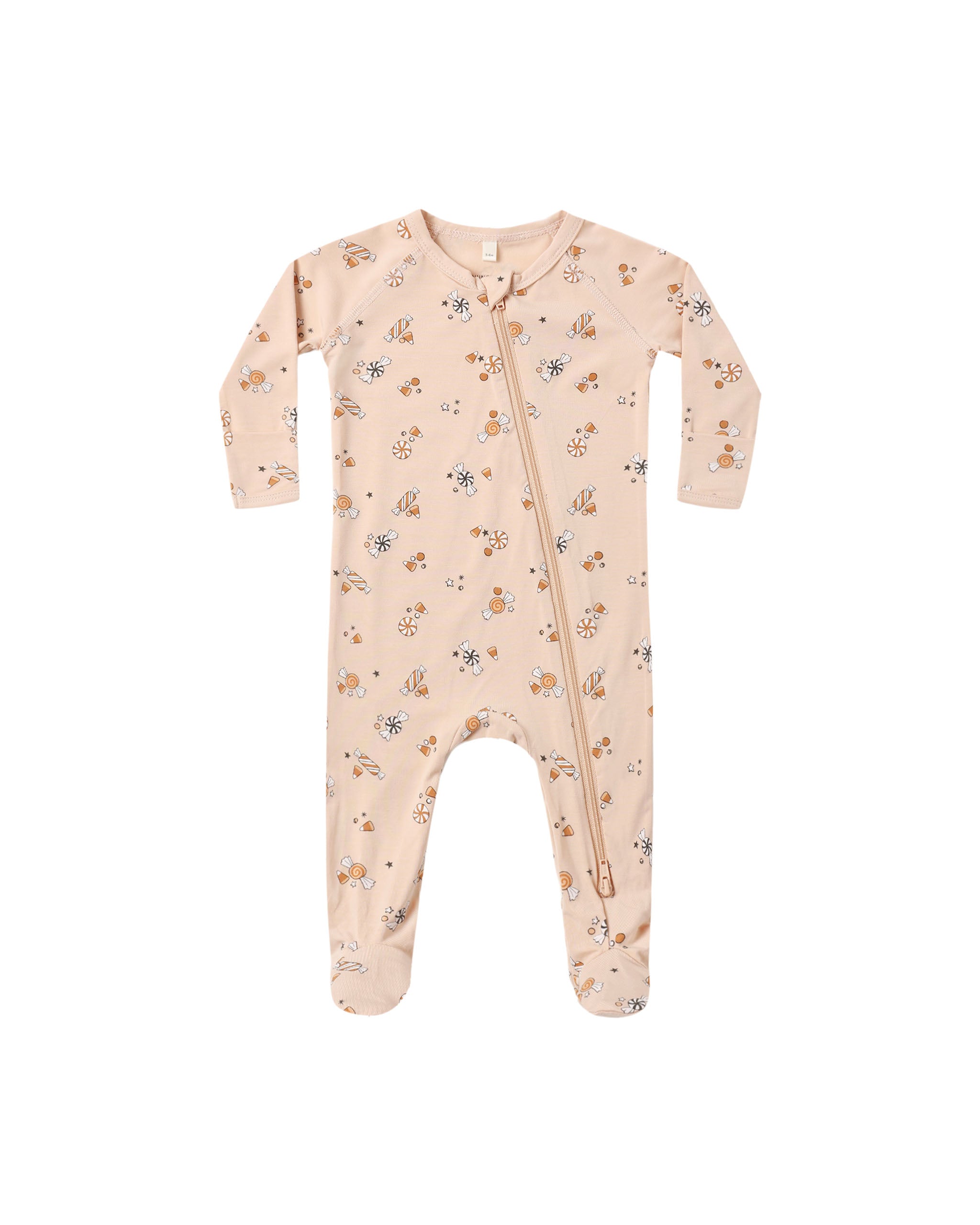 A baby long-sleeve footed sleeper in a light peach-beige color, featuring a delicate all-over print of Halloween candy, with a front zipper closure.