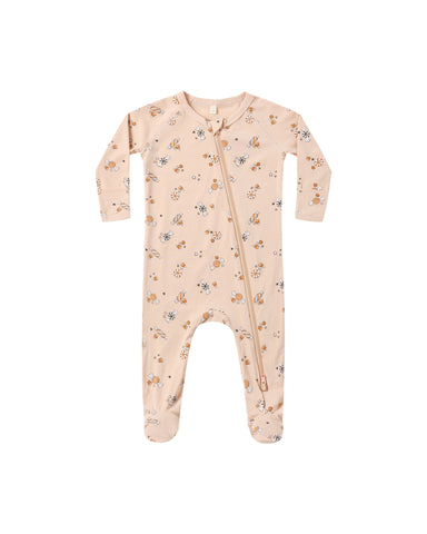 A baby long-sleeve footed sleeper in a light peach-beige color, featuring a delicate all-over print of Halloween candy, with a front zipper closure.