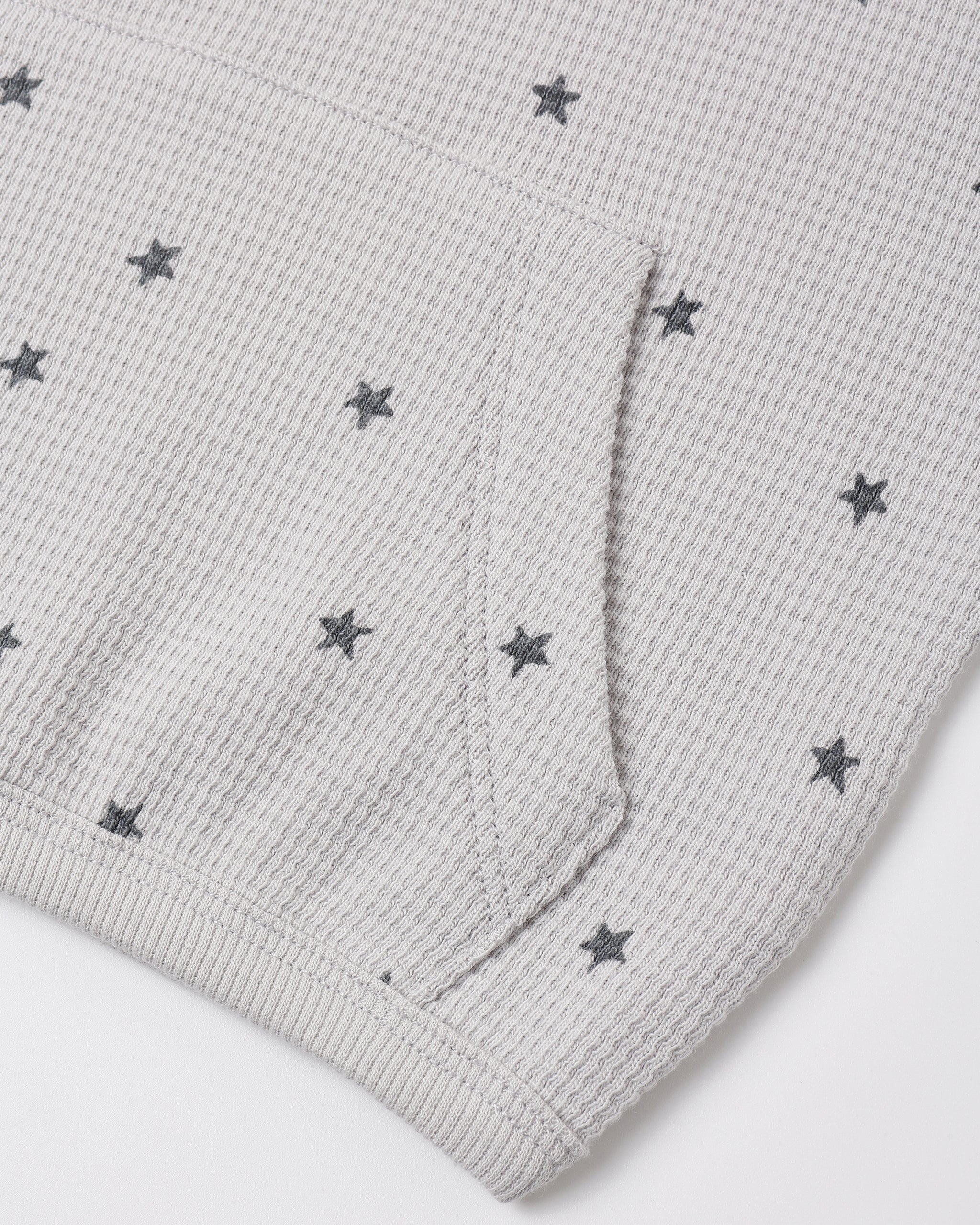 A close up a waffle grey fabric with a star pattern