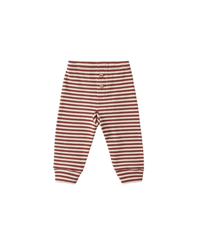 Ribbed leggings with horizontal rust red and cream stripes, featuring a wooden button closure, on a light white  background.