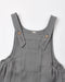 A close-up of a slate overalls with adjustable shoulder straps, decorative wooden buttons, and a front patch pocket, shown on a plain white background.
