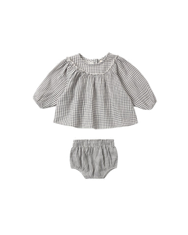 A two-piece set with a full gathered blouse, delicate ruffle details, and soft balloon sleeves, finished with a button-back closure for easy dressing. Paired with matching bloomers.
