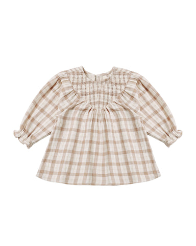 A toddler girl's long-sleeve dress featuring a beige and white gingham plaid pattern, a smocked round neckline, and ruffled cuffs, shown flat on a white background.