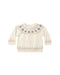 A cream-colored knit baby sweater with a Fair Isle pattern featuring gray pine trees around the yoke and a beige geometric pattern on the cuffs and hem.