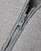 Close-up of a light gray fleece jacket with a matching gray zipper and pull tab.