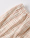 Close-up of a textured pink fabric with a subtle pattern on a light background