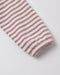 A close-up of a striped fabric sleeve or cuff with alternating dusty rose and off-white horizontal stripes, finished with a ribbed hem, on a light gray background.