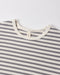 Close-up of a striped knit top with alternating gray and off-white horizontal stripes, featuring a cream ribbed crew neck and a small interior neck label reading 'GANT'.