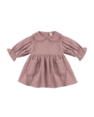 A dusty rose pink long-sleeve baby dress with a ruffled Peter Pan collar, gathered waist, and two front patch pockets with ruffle trim, shown on a plain white background.