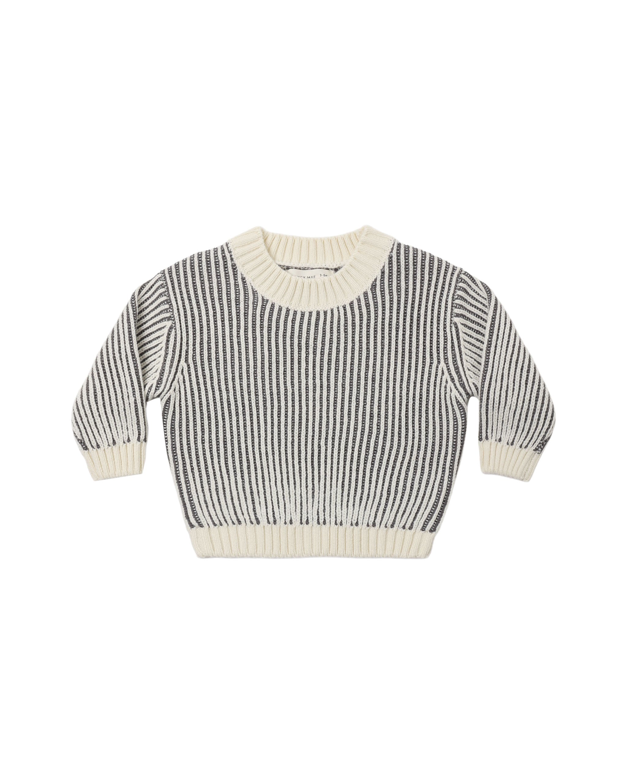 A black and cream long sleeve knit sweater on a white background