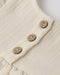 Close-up of a beige fabric with wooden buttons on a white background