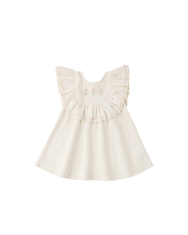 White dress with ruffled details on a white background