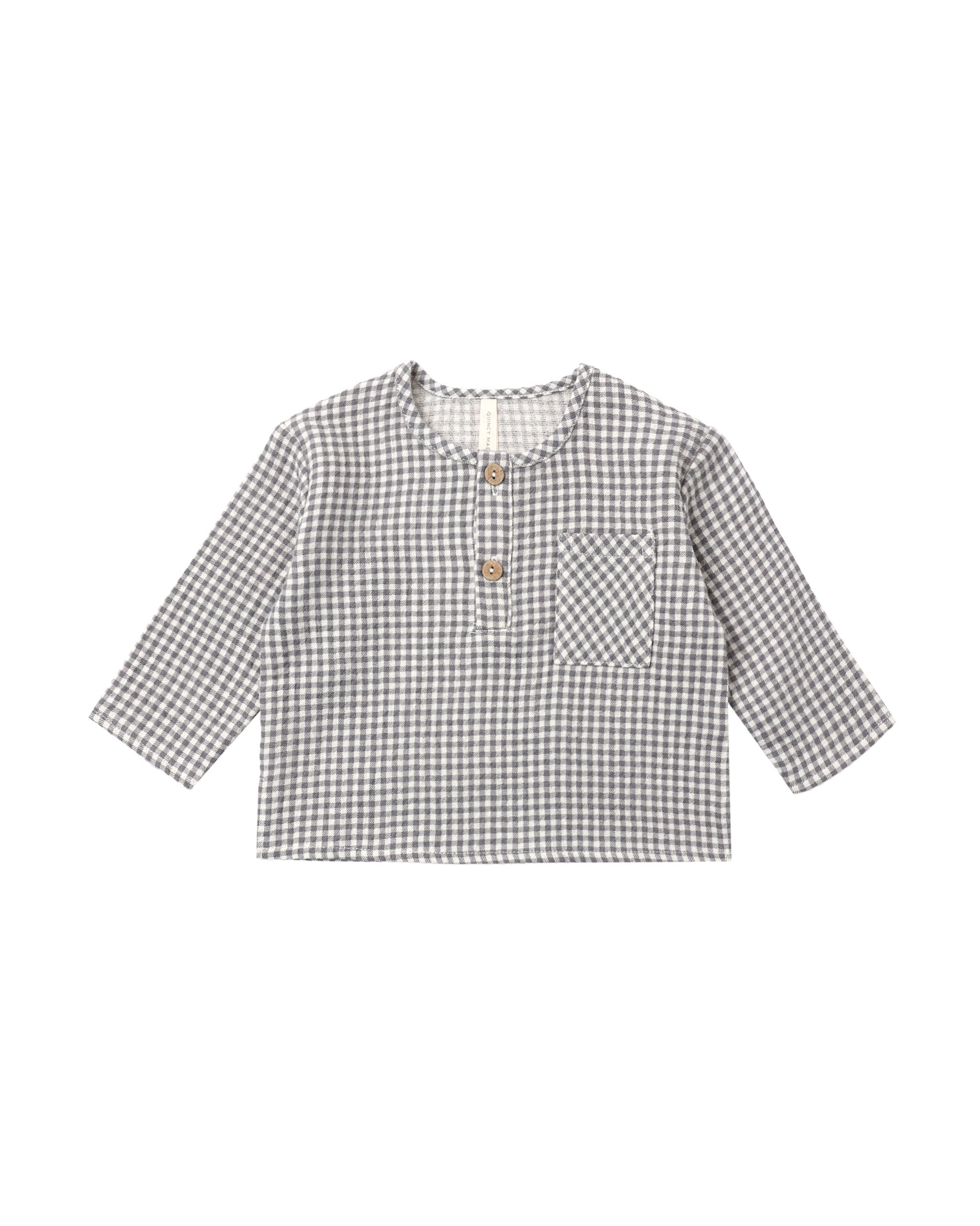 A woven black gingham long-sleeve top featuring front two-button placket and chest pocket on a white background