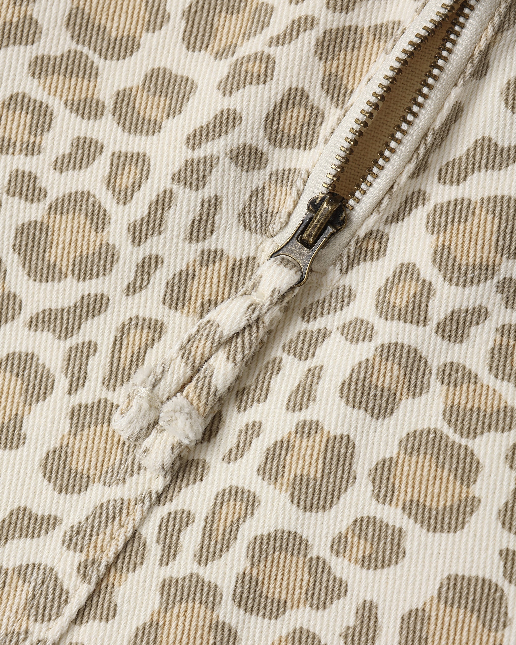 A close up of a light natural colored leopard print dress with a zippered back